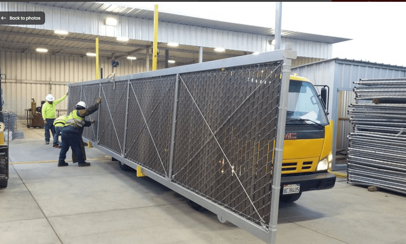Workers loading large gate onto truck.